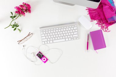 Beyaz masa üzerinde kırmızı ve mor öğelerle çalışma alanı üst görünümü