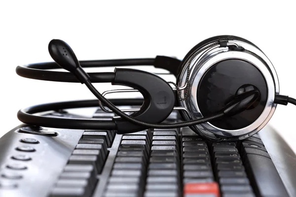 Fones de ouvido futuristas no teclado do computador preto — Fotografia de Stock