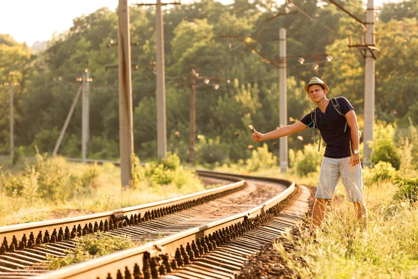 Young Man in Travel Clothing hitch hiking Railroad Train — Stock Photo, Image