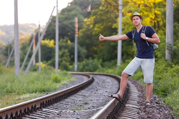 Mochilero captura de tren en el ferrocarril de campo — Foto de Stock