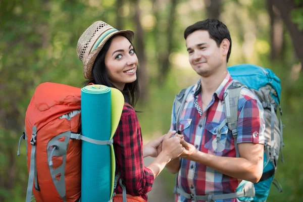 Junge Frau und Mann mit Rucksäcken Reisekleidung an Händen haltend — Stockfoto