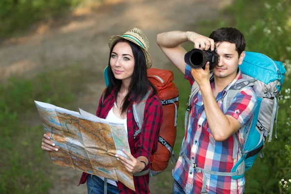 Uomo e donna sul sentiero forestale con mappa e macchina fotografica — Foto Stock