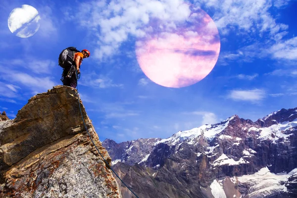 Alpinista alpino fica em penhasco rochoso com planetas no céu — Fotografia de Stock