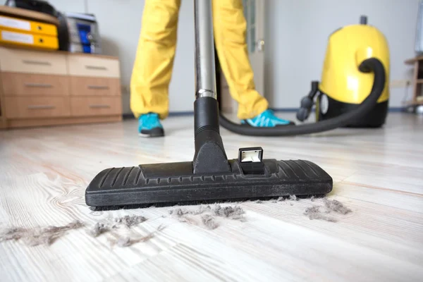 Persoon schoonmaken van houten vloer met stofzuiger — Stockfoto
