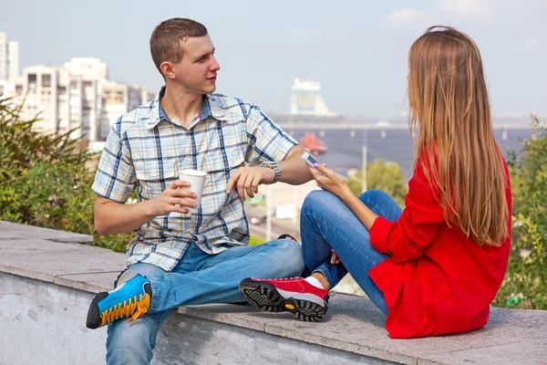 Young Man and Woman sitting on parapet in City — Stock Photo, Image