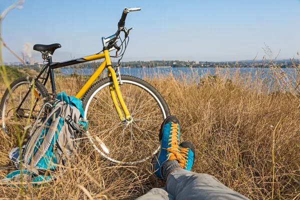 Bicyclist in bright sporty Shoes resting on Grass — Stock Photo, Image