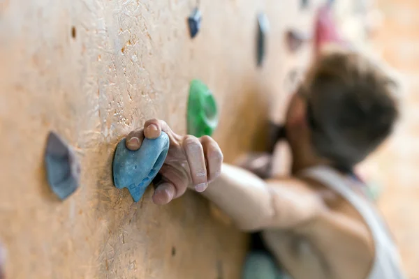 Jovem alpinista na parede do ginásio de escalada interior — Fotografia de Stock