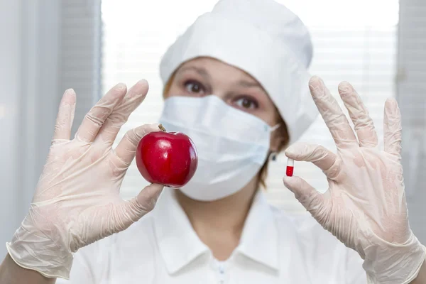Enfermera ofrece una opción de píldora y manzana — Foto de Stock