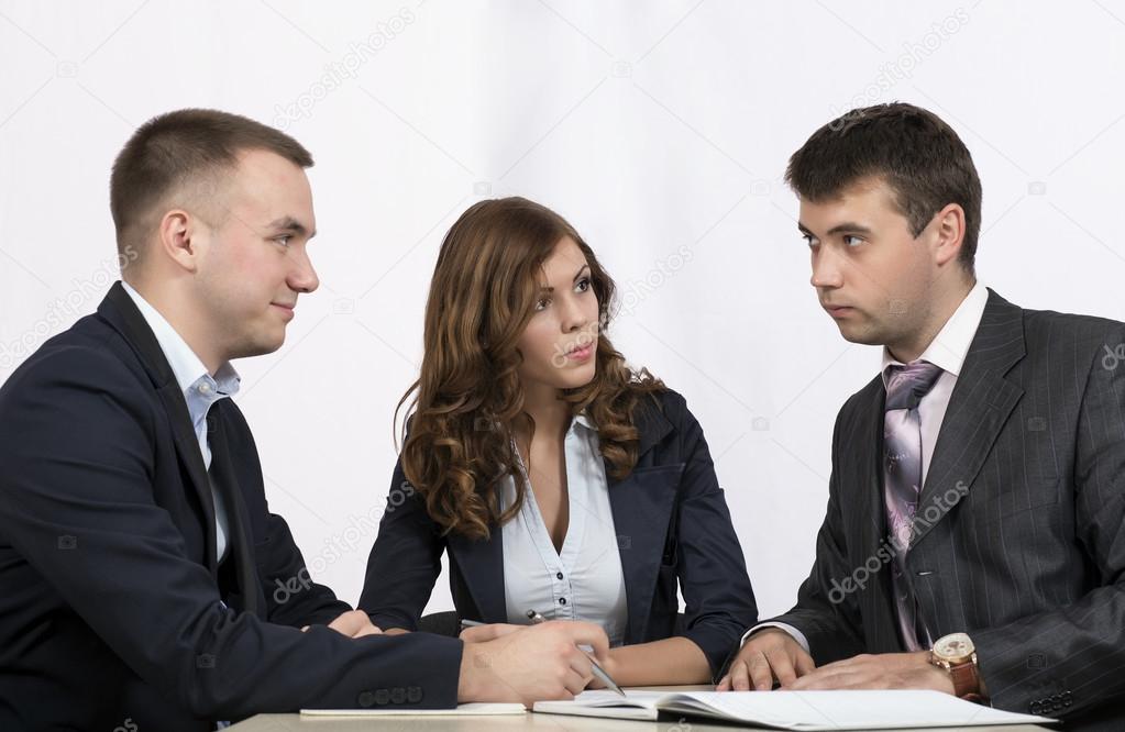 Three business people discuss the deal