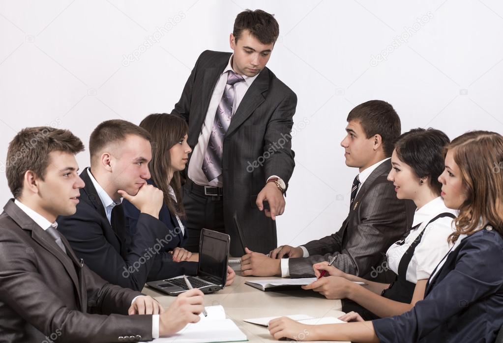 Energetic corporate manager instructs his team
