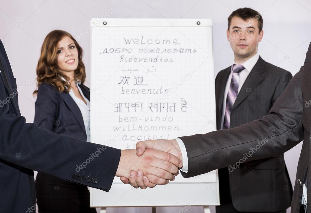 Male and female instructors welcomes attendants pointing on the flip chart