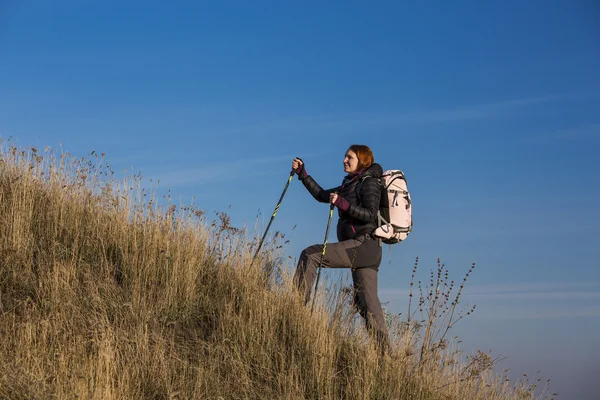 Kobiece backpacker wznosi się strome wzgórza — Zdjęcie stockowe