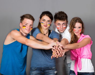 Team of young people joining hands clipart