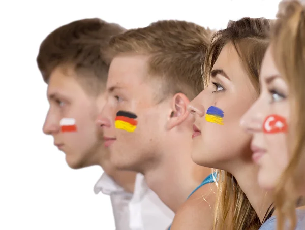 Vista lateral de las caras de cuatro adolescentes con banderas en las caras —  Fotos de Stock