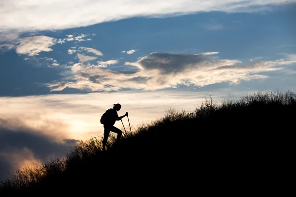 Siluetu osoby, které jsou těžké, chůzi směrem k vrcholu — Stock fotografie