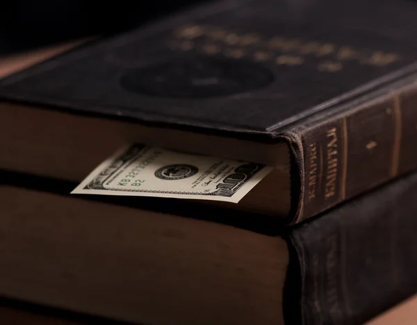 Large vintage book with dollar cash note used as tab