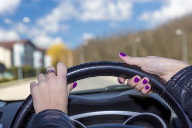 Kadın sürücünün direksiyon simidi üzerinde eller