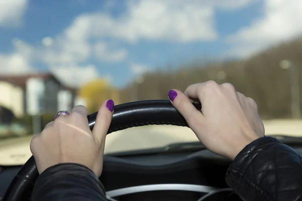 Manos del conductor femenino en el volante — Foto de Stock