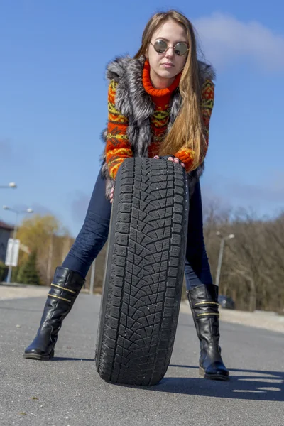 Female biker rolls big wheel — Stock Photo, Image