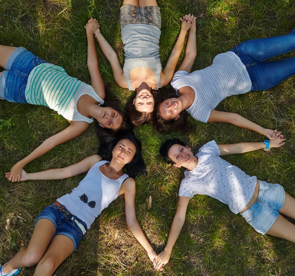 Fem unga damer på gräsbevuxen gräsmatta — Stockfoto