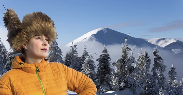 Dame souriante en chapeau de fourrure chaud hiver montagne forêt paysage sur fond — Photo