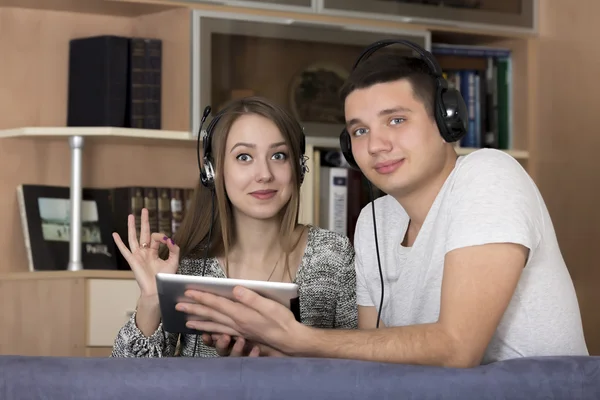 Pareja joven con dispositivo electrónico — Foto de Stock