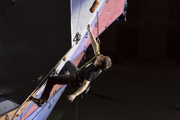 Atleta masculino faz movimento duro na parede de escalada — Fotografia de Stock