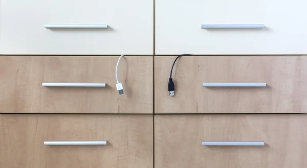 Cabinet with six boxes and black and white USB cords sticking up