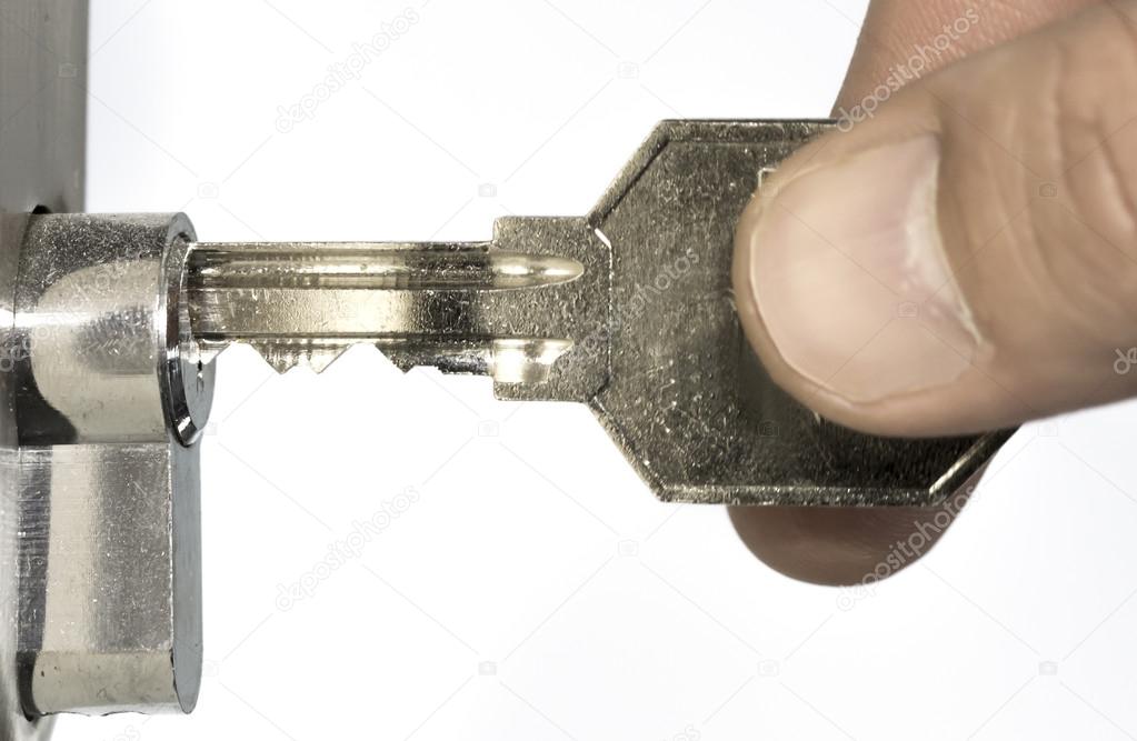 Human fingers inserting key into the door lock