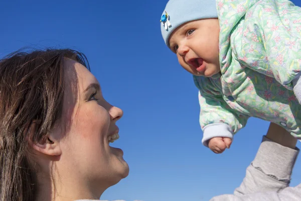 Mor och barn på blå himmel bakgrund — Stockfoto