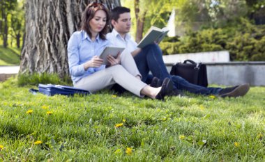 Çim ve çiçek ve iki kişi okuma