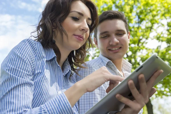 Mężczyzna i kobieta z komputera typu tablet na tle błękitnego nieba — Zdjęcie stockowe