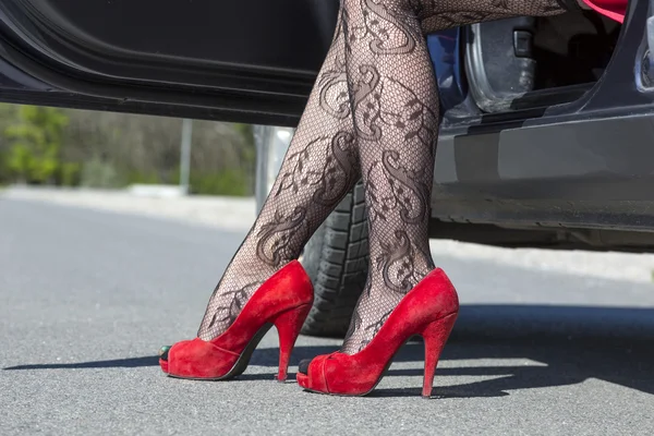 Los pies del conductor femenino elegante que camina fuera del coche —  Fotos de Stock