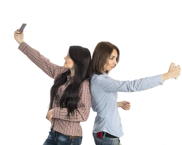 Две молодые девушки делают селфи с помощью мобильного телефона — стоковое фото
