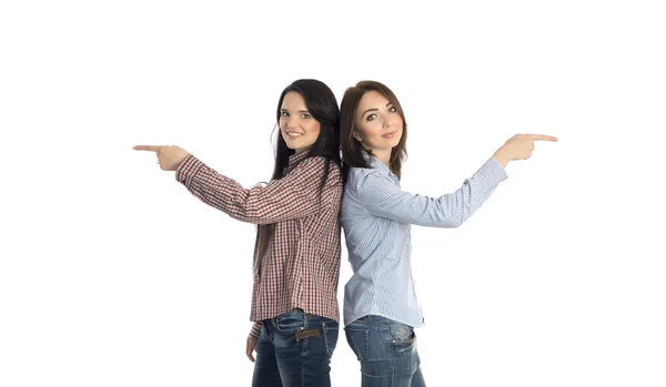 Two smiling girls pointing to opposite directions — Stok fotoğraf