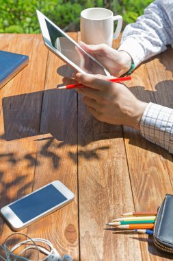 Wooden desk and man browsing gadget