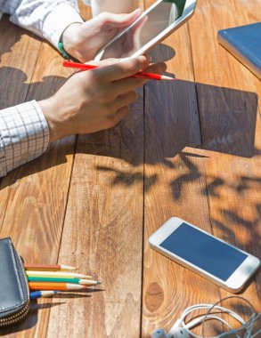 Wooden desk and man browsing gadget