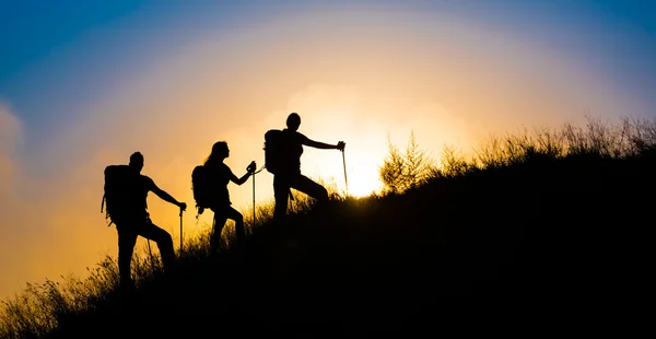 Climbers on grassy hill — Stock Photo, Image