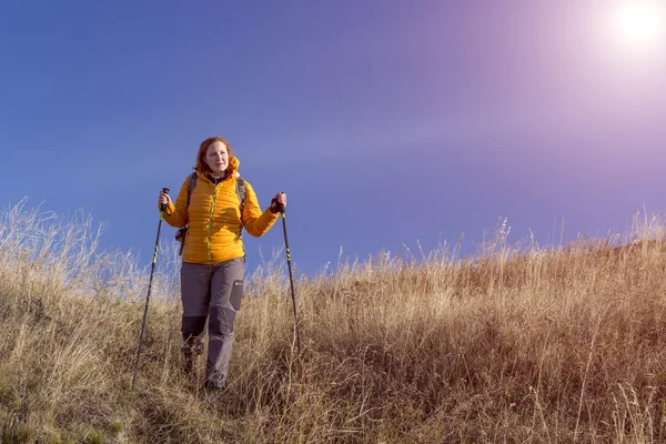 Feliz excursionista mujer caminando por hil herbáceo — Foto de Stock