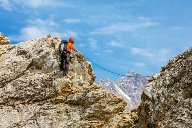 Brave man climbs rocky ridge