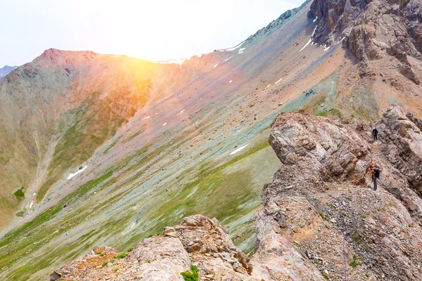 Paesaggio montano maestoso e arrampicatore femminile che attraversa cresta rocciosa — Foto Stock