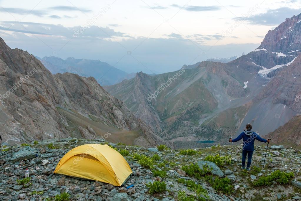 Hiker with walking poles and climbing tent