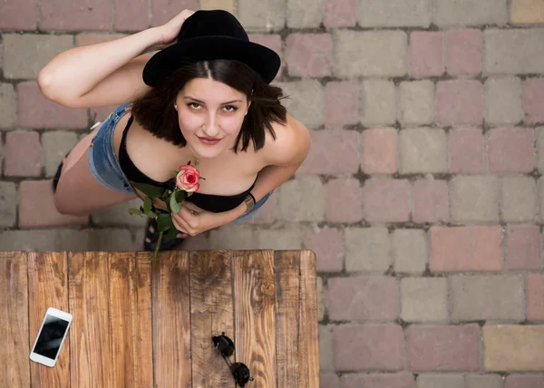 Jovem mulher bonito com chapéu preto e flor — Fotografia de Stock