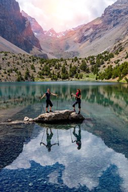 Two smiling females staying Among Blue Mountain Lake
