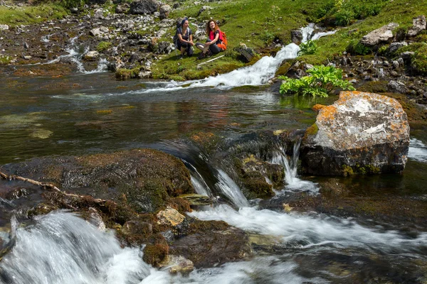 People relaxing next to mountain river — Stockfoto