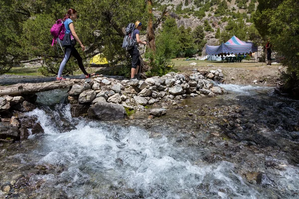 Hikers crossing river — Zdjęcie stockowe