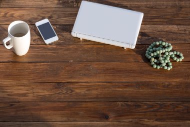 Ahşap masa Laptop telefon kupa ve tesbih ile