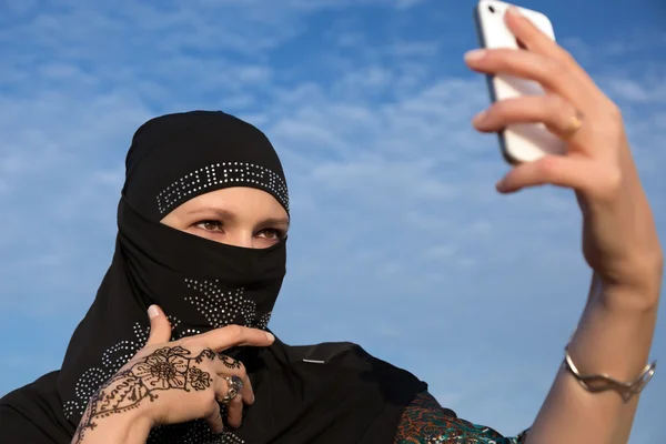Lady in zwarte Hijab bedrijf telefoon — Stockfoto