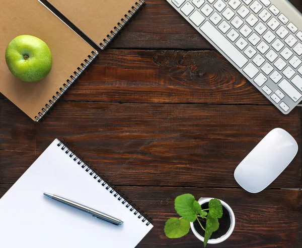 Donkere bruine houten bureau met briefpapier en elektronica — Stockfoto