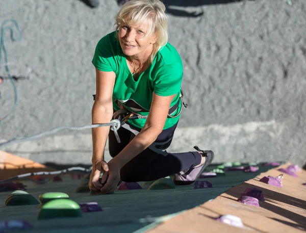 Usmívající se starší dáma na extrémní lezecké stěně — Stock fotografie